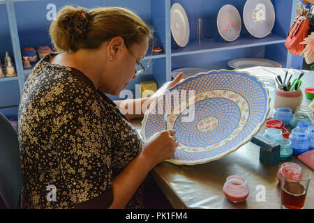 Artist woman of Art Ceramics is painting the beautiful ceramic dish in Selcuk, Izmir, Turkey. Stock Photo