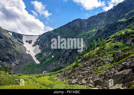 Summer Mountain Landscape: View of Ravine covered by Snow at Siberian Rocks Stock Photo