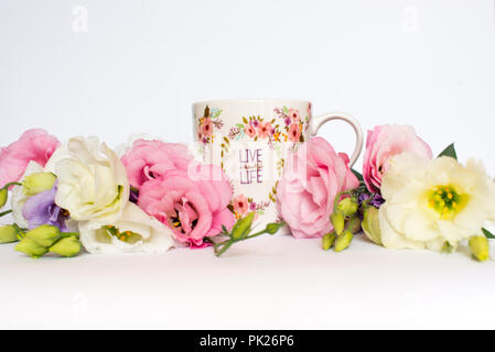 Cup of tea with flowers on white background. Copy space Stock Photo