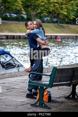 Happy young woman clinging on to a boys body as they cuddle each other in York, England Stock Photo