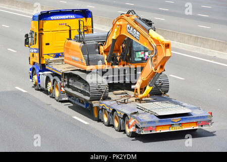 HGV lorry truck & low loader transport for Case construction equipment CX210C Diesel Hydraulic crawler excavator digger machine driving on UK motorway Stock Photo