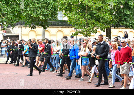 London street scene crowds of people & marshals control group walking The Mall towards Buckingham Palace at RAF centenary parade & flypast England UK Stock Photo