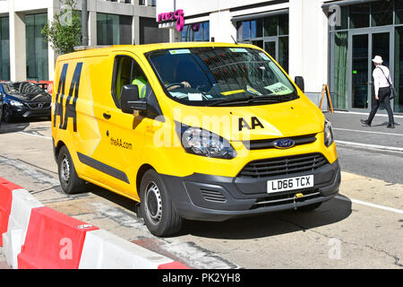 Ford Transit van & driver with AA logo on yellow breakdown van driving along town centre in road works Stratford Newham East London England UK Stock Photo