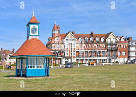 Was Grand Hotel now Grand Apartments  victorian building &  modern clock tower shelter on greensward holiday seaside resort  Frinton on Sea Essex UK Stock Photo