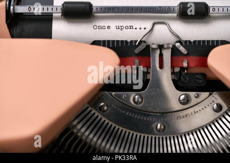 Vintage typewriter coral color in studio, close up. Stock Photo