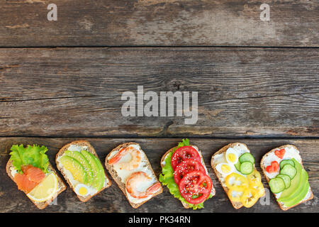 Of different sandwiches on the old wooden background. Top view. Flat lay. Stock Photo