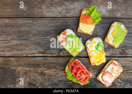 Of different sandwiches on the old wooden background. Top view. Flat lay. Stock Photo