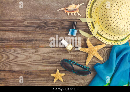 Summer accessories on wooden old background. Top view. Toned image. Stock Photo