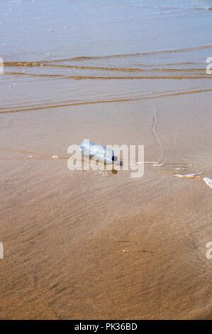Discarded plastic bottle polluting a beach Stock Photo