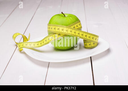 Apple with centimeter on the plate. Healthy eating Stock Photo