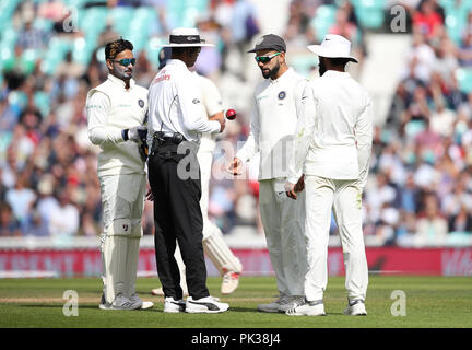 India's Virat Kohli (2nd right) checks the shape of the ball with the umpire during the test match at The Kia Oval, London. Stock Photo