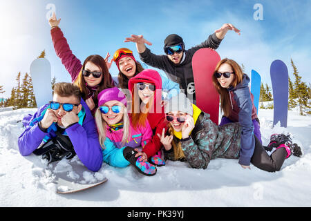 Happy friends skiers and snowboarders having fun at ski resort. Winter vacations concept Stock Photo