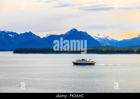 The National Geographic tour ship 'Sea Lion' at dawn in the entrance to Glacier Bay, Alaska, USA - Viewed from a cruise ship sailing the Inside Passag Stock Photo