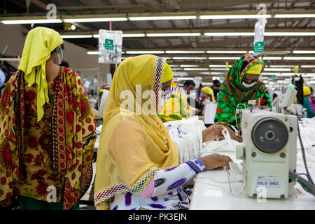 A woman working on a sewing machine at a garment factory in Dhaka, Bangladesh. Stock Photo
