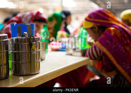 Garment workers having their lunch in the canteen at a garment factory in Bangladesh. Stock Photo