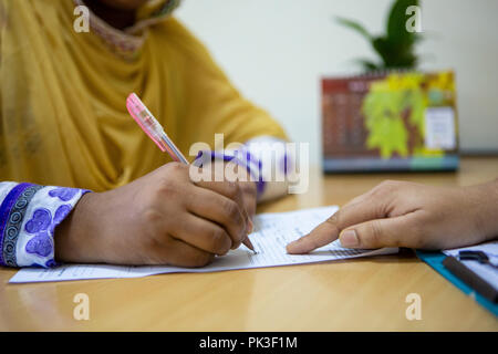 A female garment worker meeting with her manager in garment factory in Bangladesh. Stock Photo