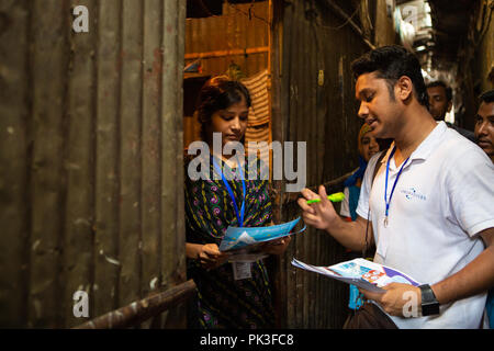A garment worker using a mobile phone to share feedback on the working conditions at the garment factory where she works. Stock Photo