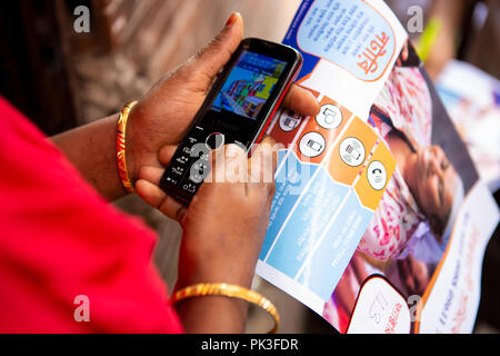 A garment worker using a mobile phone to share feedback on the working conditions at the garment factory where she works. Stock Photo