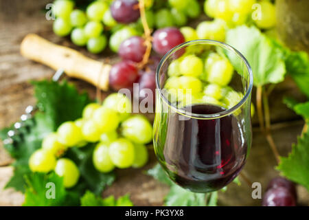 Wine background. Red wine in glasses close-up, bottle, grapes on vintage background, wine concept. Stock Photo