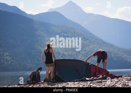 Couple making preparation for setting up a tent Stock Photo