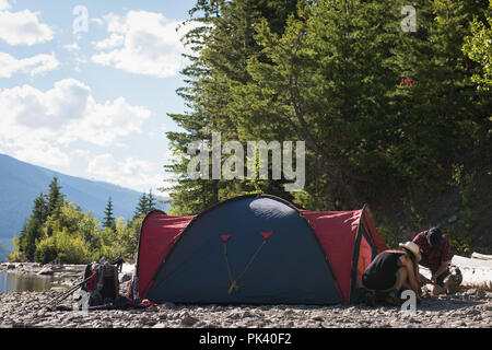 Couple setting up tent at countryside Stock Photo