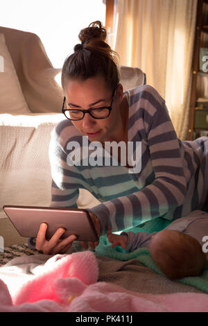 Mother with baby using digital tablet on the floor Stock Photo
