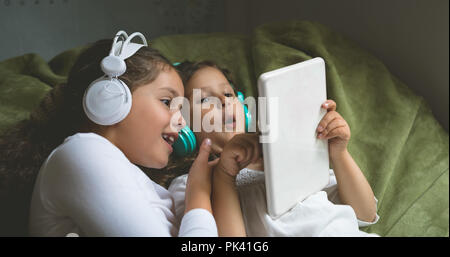 Siblings listening music while using digital tablet Stock Photo