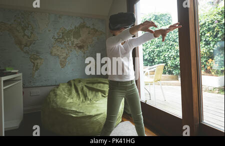 Girl using virtual reality headset in living room Stock Photo