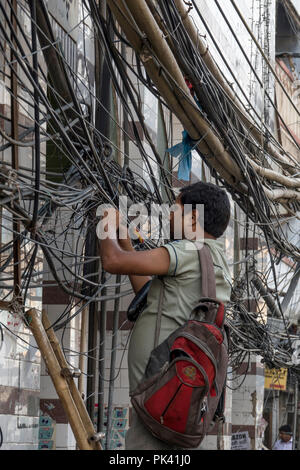 Technician fixing power lines in Old Delhi, New Delhi, Delhi, India Stock Photo