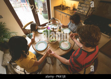 Family praying before having a meal Stock Photo