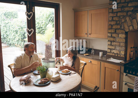 Senior couple having breakfast in kitchen Stock Photo