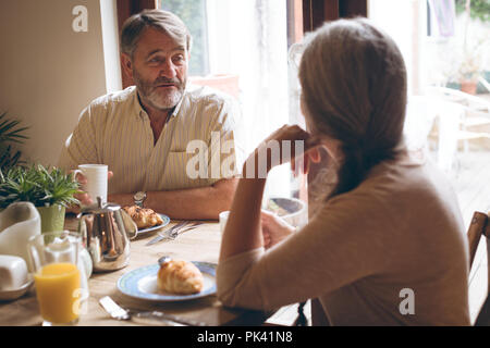Senior couple interacting with each other while having breakfast Stock Photo