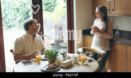 Senior couple interacting with each other while having breakfast Stock Photo