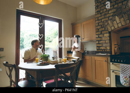 Senior couple interacting with each other while having breakfast Stock Photo