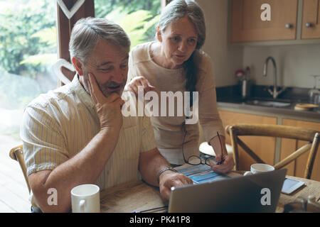 Senior couple using laptop on dining table Stock Photo