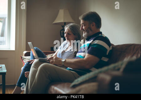 Senior couple using laptop in living room Stock Photo