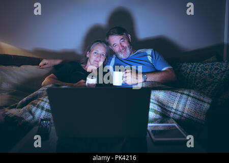 Senior couple watching laptop while having coffee at home Stock Photo