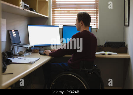 Disabled man working on computer Stock Photo
