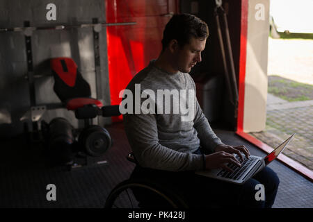 Disabled man using laptop in workshop Stock Photo