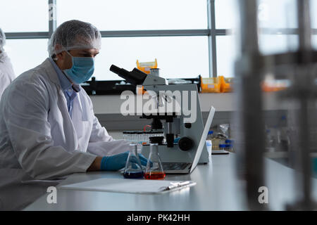 Male scientist using microscope in laboratory Stock Photo - Alamy