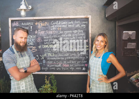 Couple standing near menu board in food truck Stock Photo