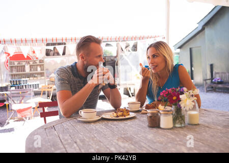 Couple having breakfast in outdoor cafe Stock Photo