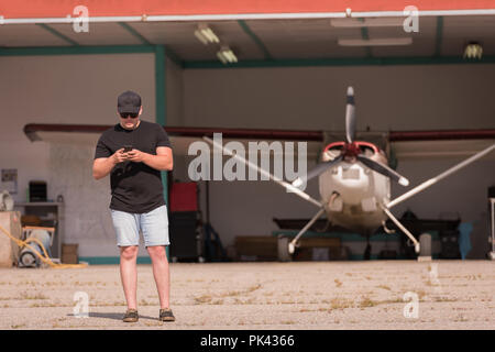 Mechanic using mobile phone Stock Photo
