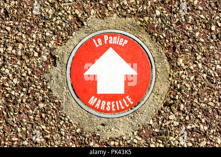 View from above of marker sealed in the pavement in the city center of Marseille, France, to indicates the way to the historical district of Le Panier Stock Photo
