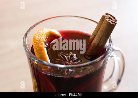 Mulled wine in glass with spice and fruit on wooden table. Close up Stock Photo