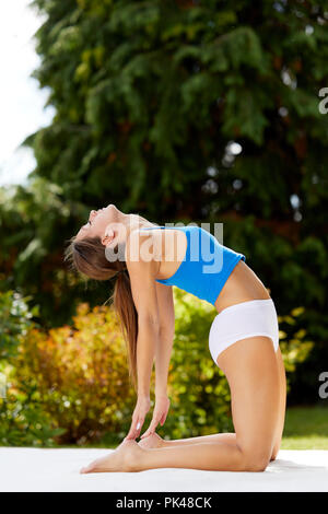 Girl practicing Yoga outdoors Stock Photo