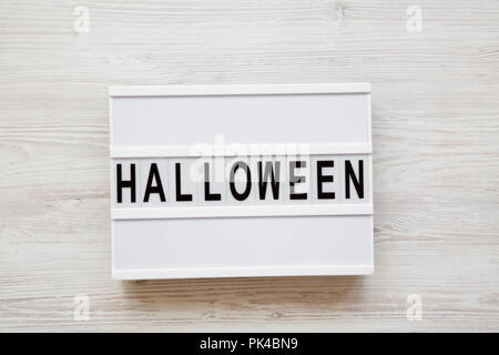 'Halloween' word on lightbox over white wooden background, top view. From above, overhead. Stock Photo