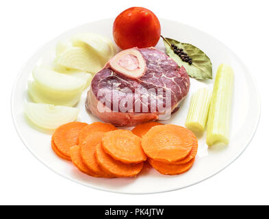 prepared raw products on white plate for cooking italian dish Osso Buco cutout on white background Stock Photo