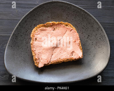 bread sandwich with pate a on black plate on dark wooden board Stock Photo