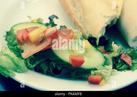 White baguette cheddar cheese and chutney sandwich with side salad, filter applied Stock Photo